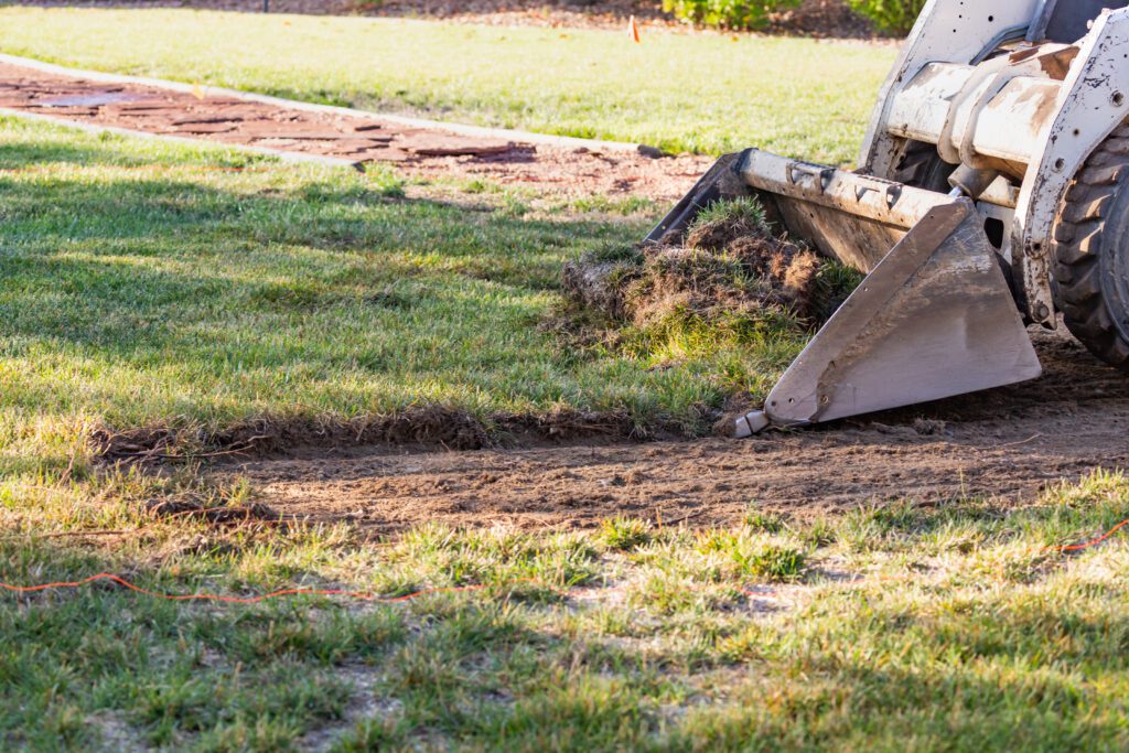 Small Bulldozer Removing Grass From Yard Preparing For landscape