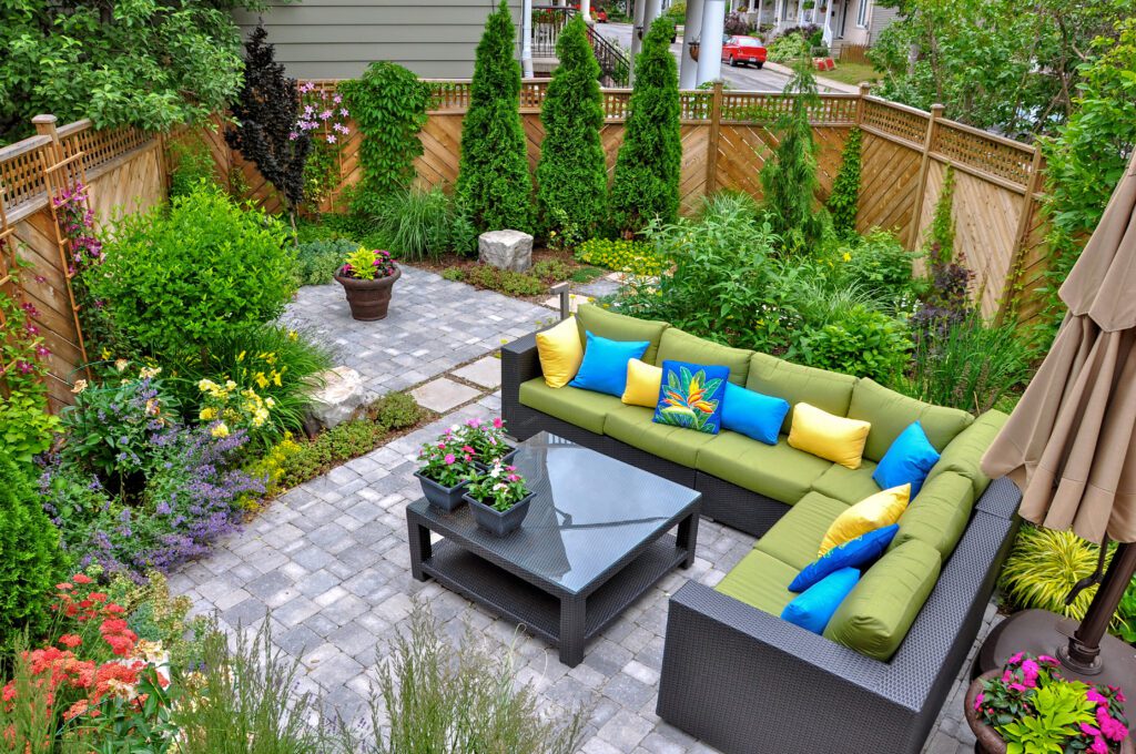 A beautiful small, urban backyard garden featuring a tumbled paver patio